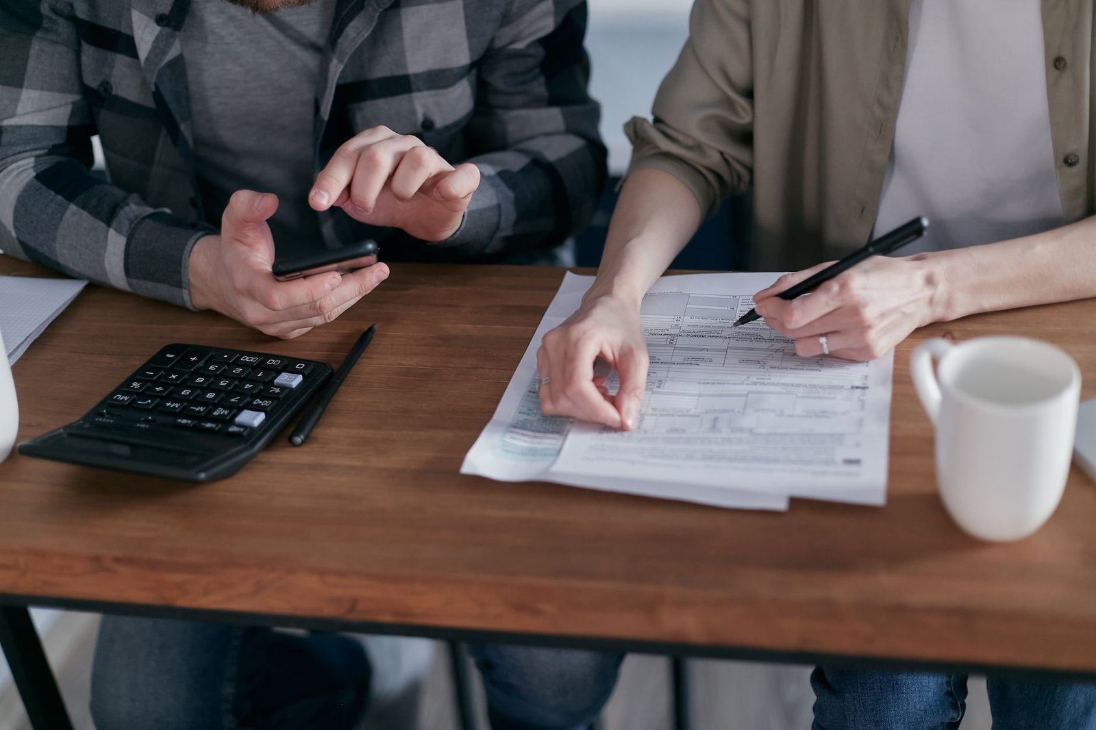Two people comparing an explanation of benefits with medical bills before filing an appeal