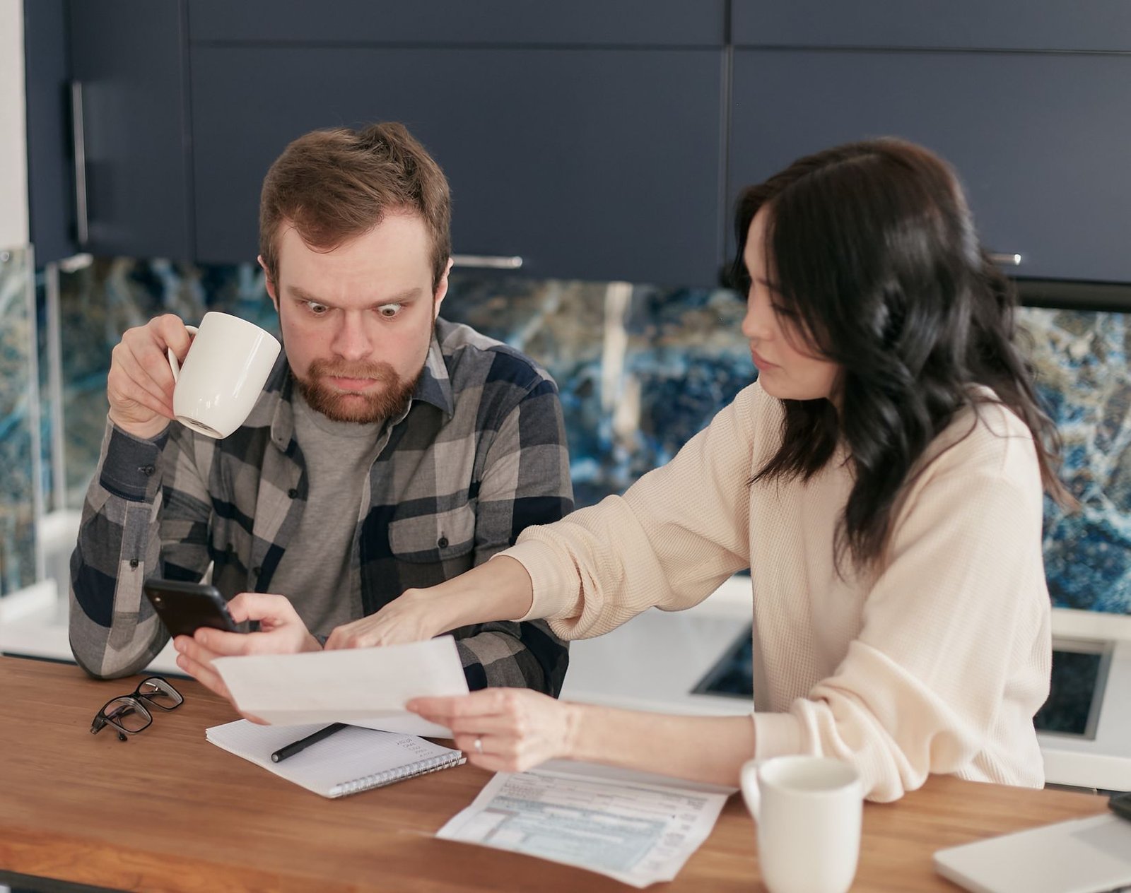 Person on the phone at a kitchen table negotiating an out of network medical bill