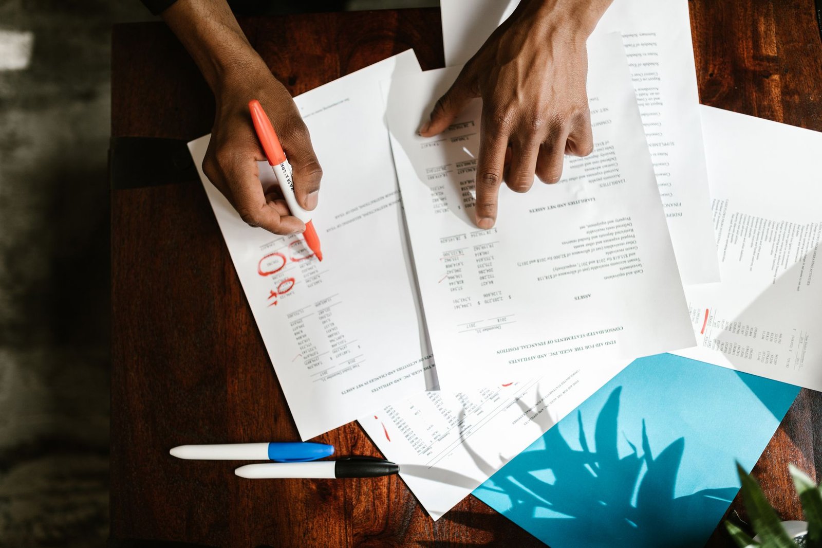 Person reviewing printed medical billing paperwork at a desk, representing a line-by-line hospital bill audit