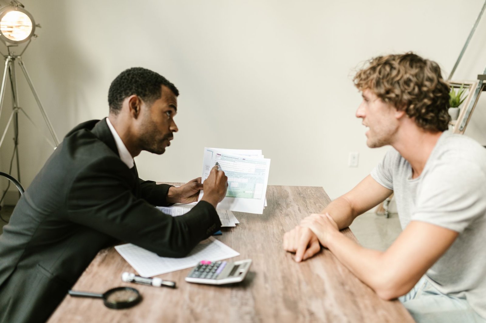 Two people matching an explanation of benefits to a provider bill line by line at a desk